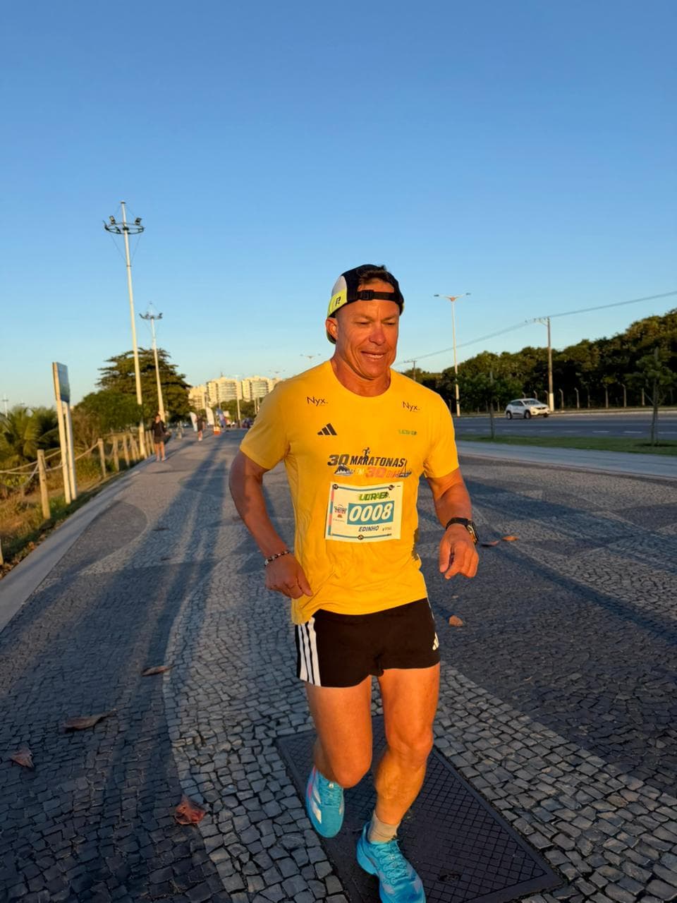 Edinho correndo ao amanhecer com o número de peito 0008 durante as 30 maratonas em 30 dias