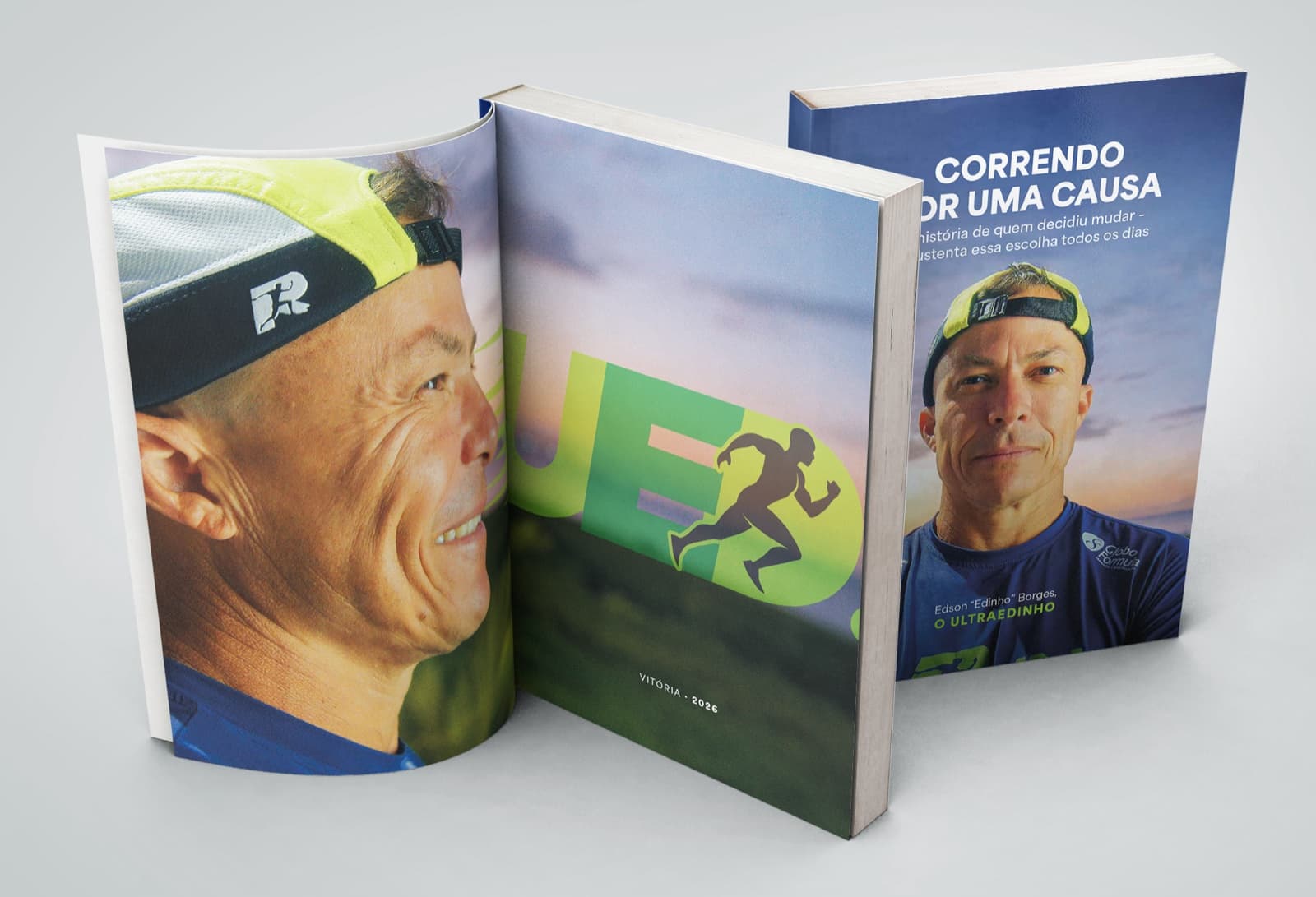 Três exemplares do livro: um aberto na página de rosto com a marca UED, um em pé de capa e um de lombada